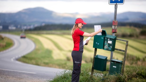 Mailman delivering mail in mailboxes