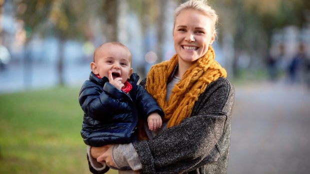 Smiling mother with her baby in her hands