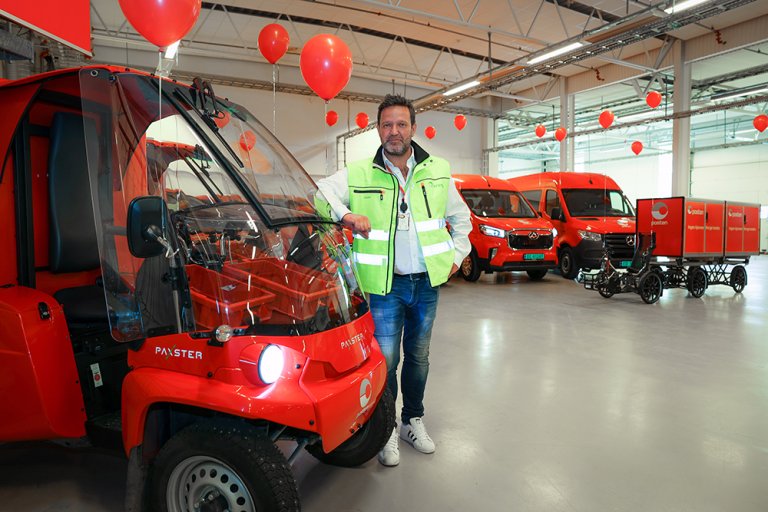 Mann sammen med ulike elektriske kjøretøy fra Posten