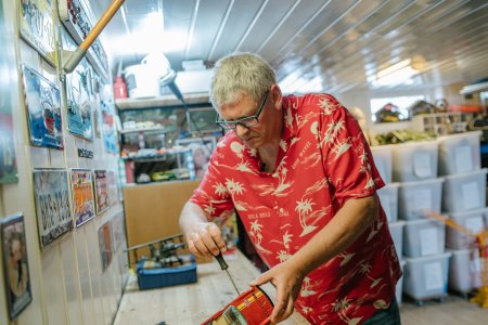 Mann reparerer en gammel lekebil i verkstedet sitt.