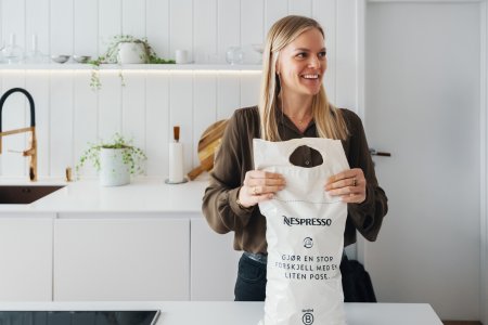 Kvinne med Nespresso-pose til gjenvinning